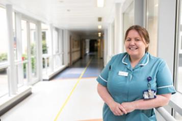 Friendly nurse in hospital corridor