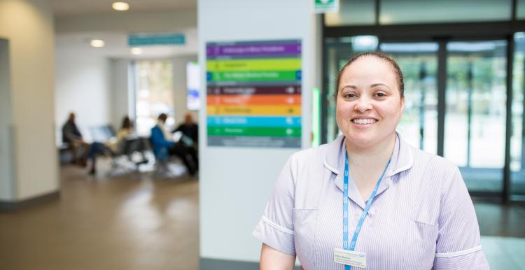 A nurse smiling at the camera in a hospital