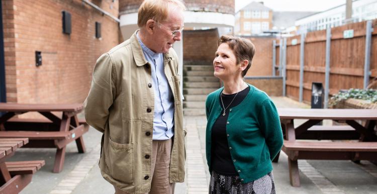 A man and a woman smiling and talking to each other