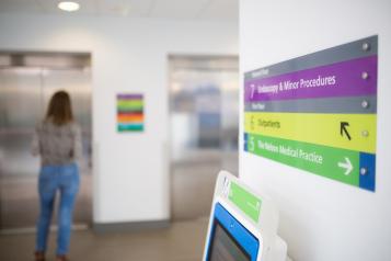 Woman waiting for a lift in a hospital setting