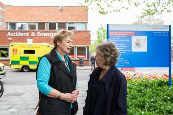Two older women talking outside a hospital