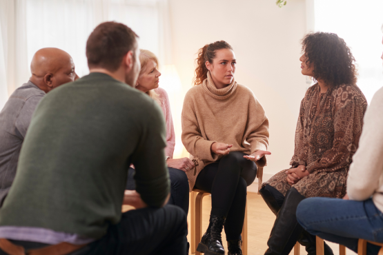 Image of a group of people seated in a circle having a discussion.