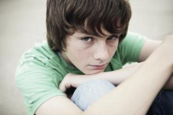 Boy sitting hugging knees Boy sitting hugging knees