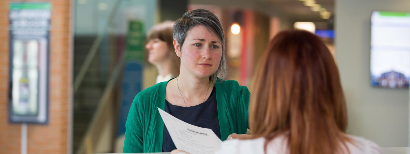 Woman at reception desk trying to complain