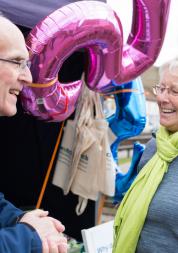 Elderly man and woman talking together at a Healthwatch event