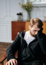 Man sitting in chair with head in hands